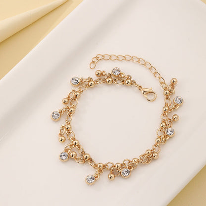 Gold tassel bracelet with diamond detailing close-up